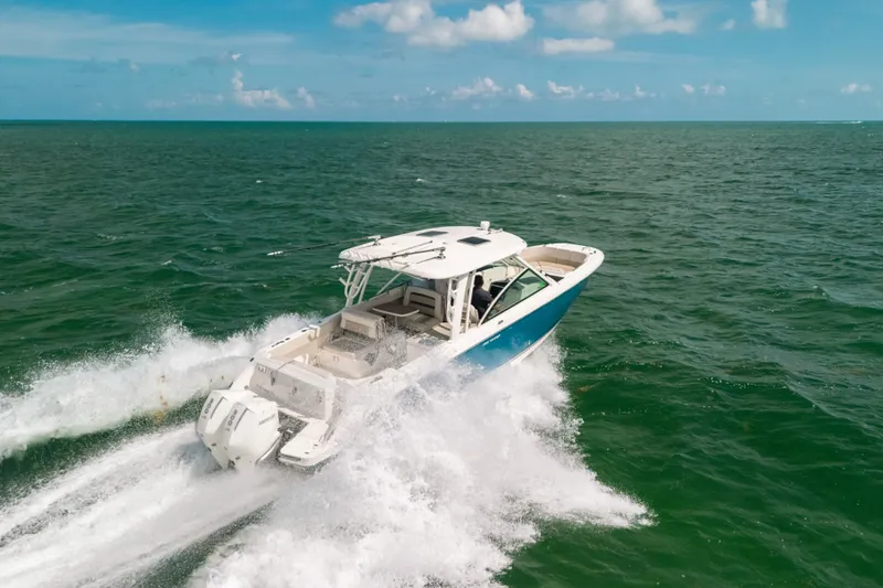 Slide: The Image of 2024 Boston Whaler 320 Vantage cruising on open sea under clear skies. - 10