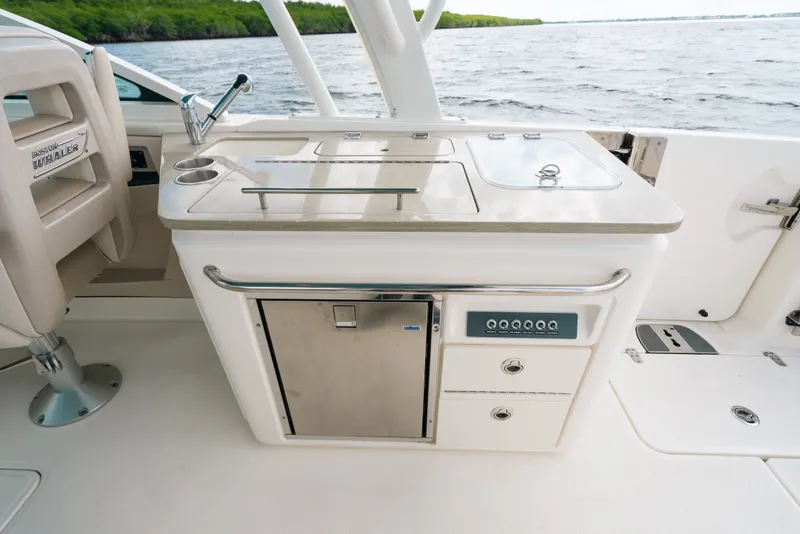 Slide: The Image of 2024 Boston Whaler 320 Vantage boat interior with kitchenette and seating, overlooking water. - 31