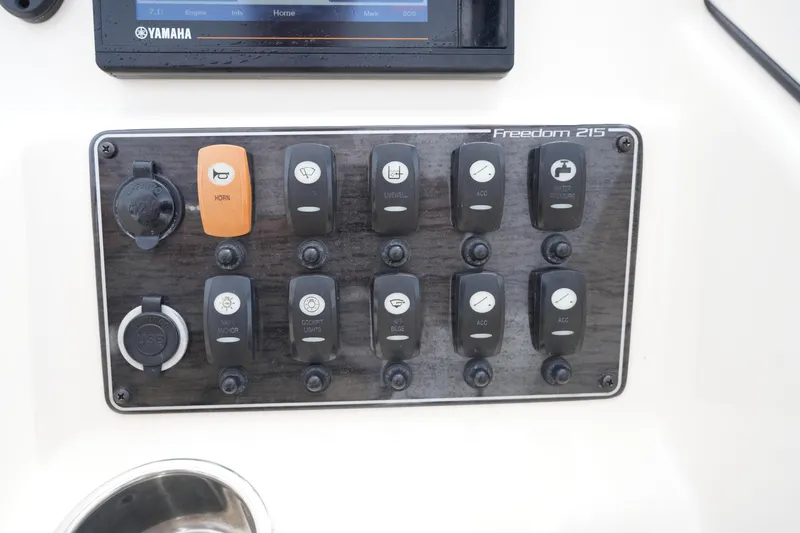 Slide: The Image of Control panel of 2022 Grady-White Freedom 215 boat with various switches and USB port. - 24