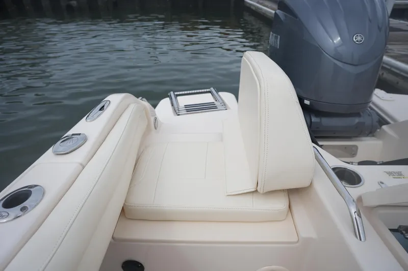 Slide: The Image of 2022 Grady-White Freedom 215 boat interior with cushioned seating and outboard motor. - 13