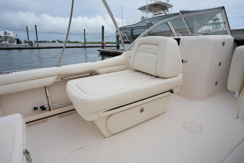 Slide: The Image of 2022 Grady-White Freedom 215 boat interior with luxurious seating at a marina. - 16