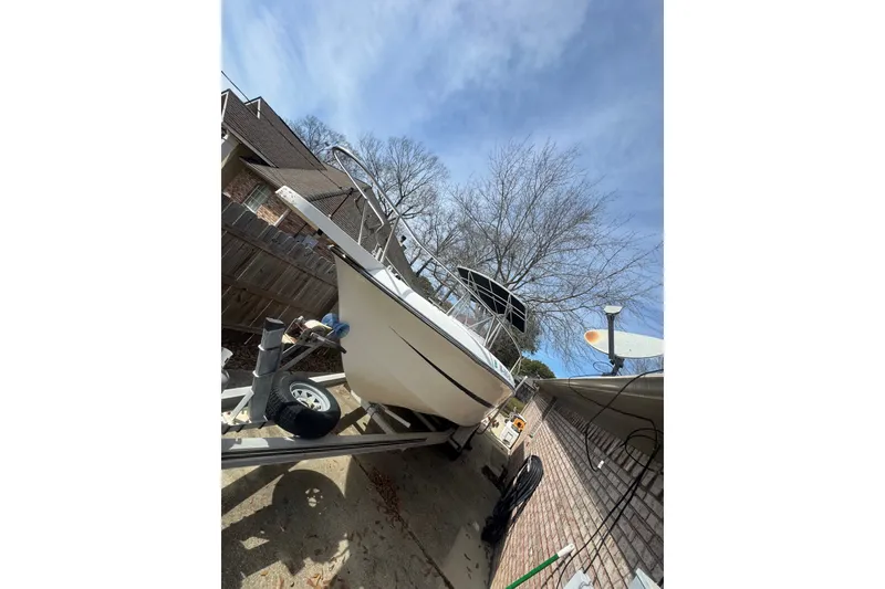 Slide: The Image of 1993 Hydra-Sports 2300 CC boat on trailer, parked in driveway under clear sky. - 13