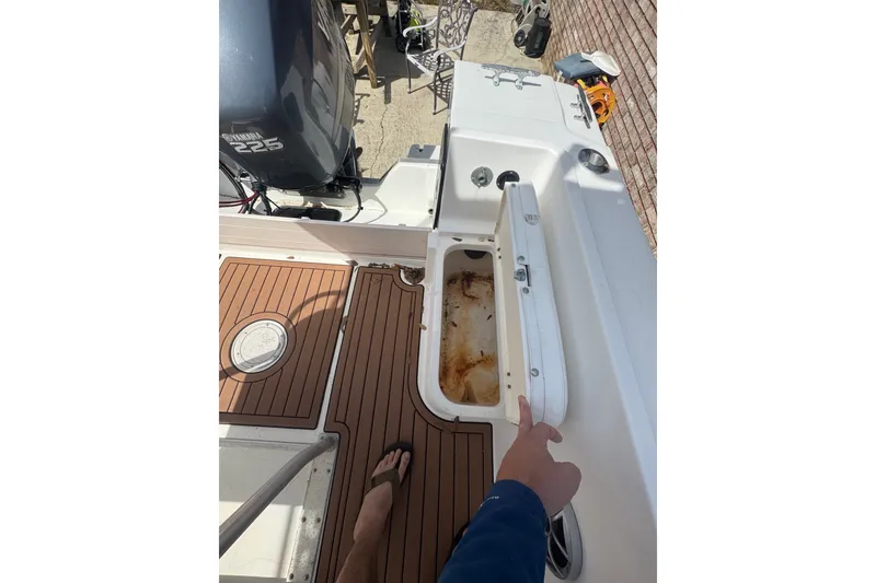 Slide: The Image of 1993 Hydra-Sports 2300 CC boat deck with open storage compartment and Yamaha 225 engine. - 6
