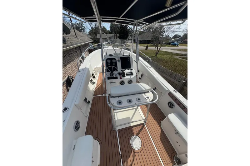 The Image of 1993 Hydra-Sports 2300 CC boat interior with steering console and seating, featuring wood-style flooring. - 1