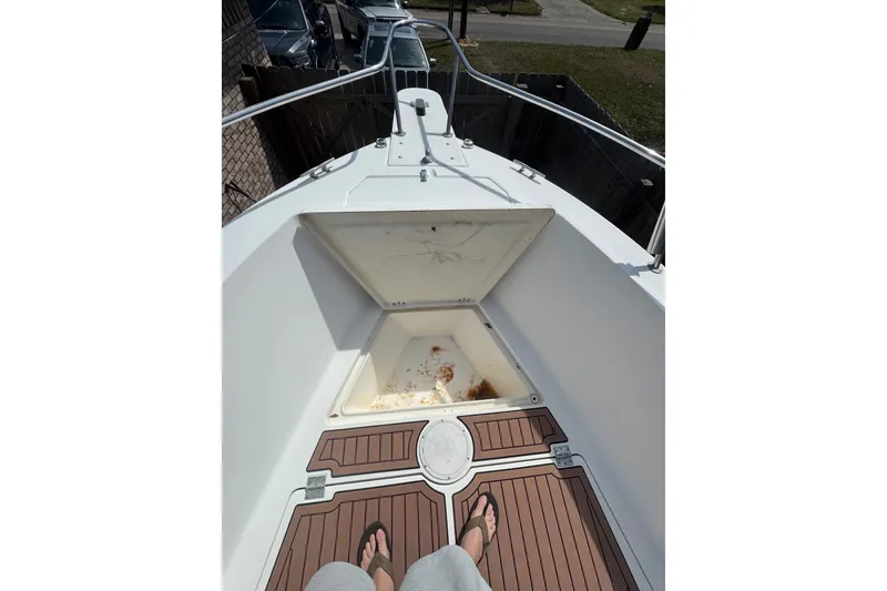 Slide: The Image of 1993 Hydra-Sports 2300 CC boat deck with open storage compartment, featuring teak-style flooring. - 4
