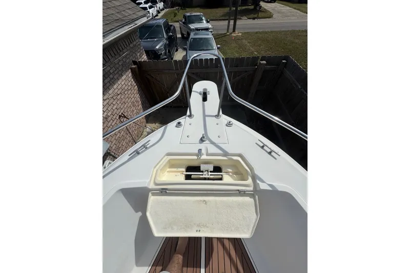 Slide: The Image of 1993 Hydra-Sports 2300 CC boat deck with open storage compartment, parked near vehicles. - 2