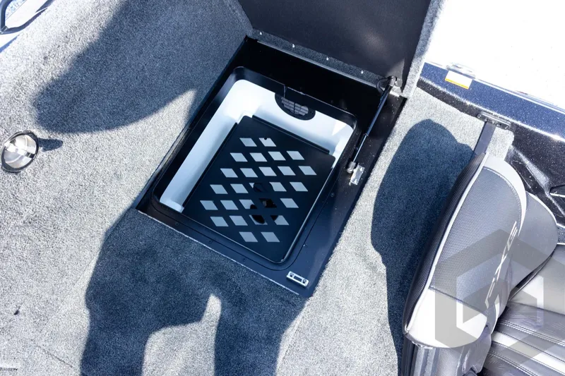 Slide: The Image of 2027 Skeeter FXE21 Apex boat storage compartment with carpeted interior and seating. - 24
