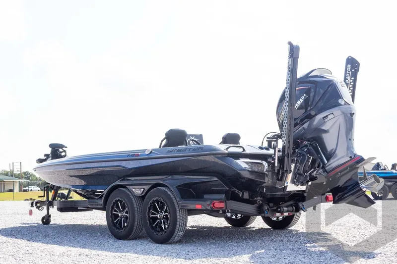 Slide: The Image of 2027 Skeeter FXE21 Apex boat with dual motors on a trailer, parked outdoors. - 8
