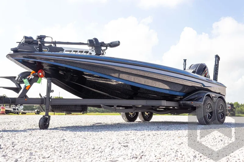 Slide: The Image of 2027 Skeeter FXE21 Apex boat on trailer, sleek design, parked on gravel. - 2
