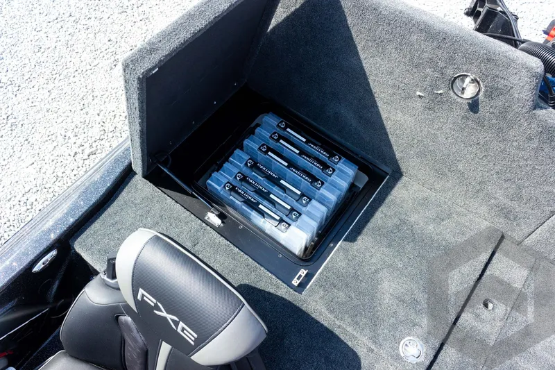 Slide: The Image of 2027 Skeeter FXE21 Apex boat storage compartment with organized tackle boxes and FXE seat. - 23