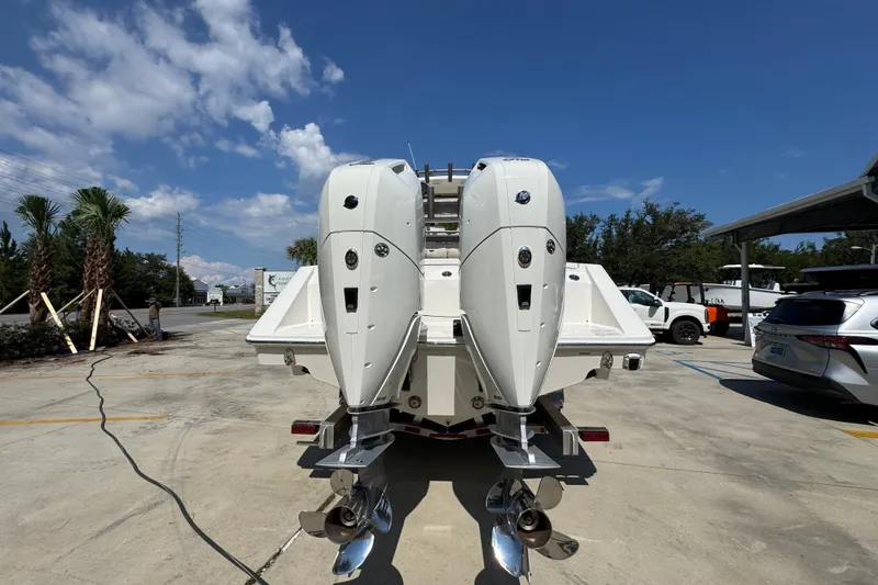 Slide: The Image of 2027 Solace 32CS boat with dual outboard engines in a sunny parking lot. - 15