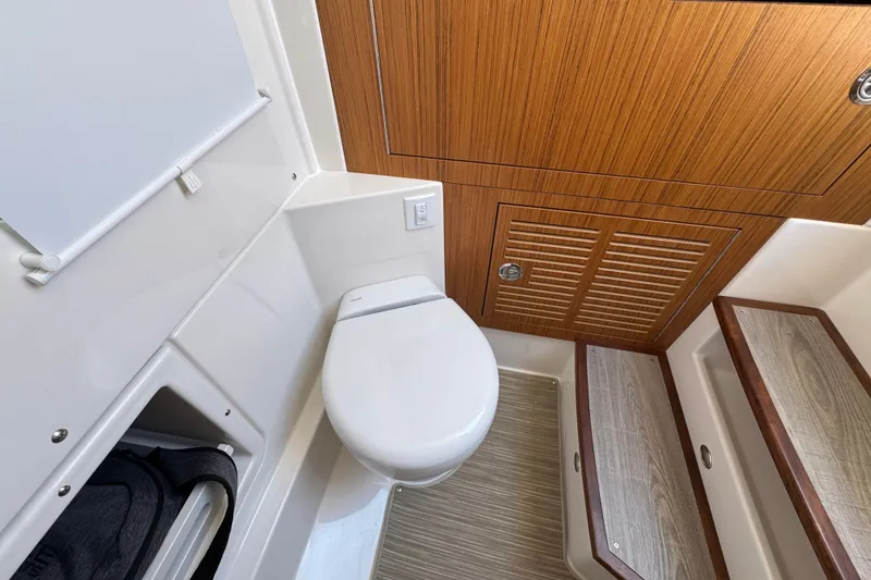Slide: The Image of Modern bathroom interior in 2027 Solace 32CS boat, featuring wooden cabinetry and compact design. - 32