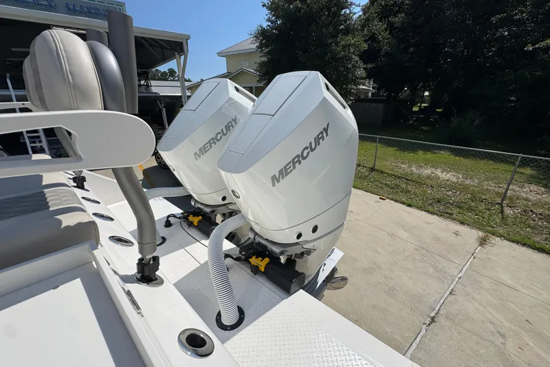 Slide: The Image of Twin Mercury outboard engines on a 2027 Solace 32CS boat, parked outdoors. - 53