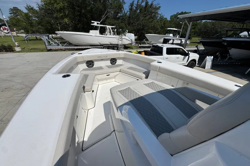 Slide: The Image of 2027 Solace 32CS boat interior with spacious seating and modern design at a marina. - 21