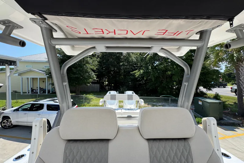 Slide: The Image of 2027 Solace 32CS boat interior with life jacket storage, parked near a residential area. - 36