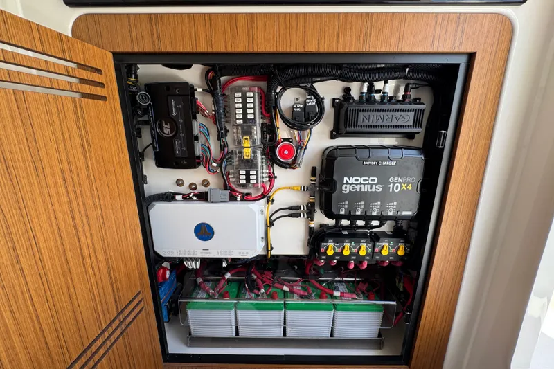 Slide: The Image of Electrical panel of a 2027 Solace 32CS boat, featuring NOCO Genius charger and Garmin equipment. - 33