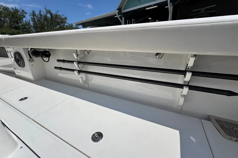 Slide: The Image of 2027 Solace 32CS boat interior with rod holders and speaker, under clear blue sky. - 49