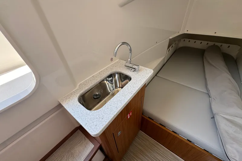 Slide: The Image of Compact cabin interior of 2027 Solace 32CS with sink and cushioned seating. - 31