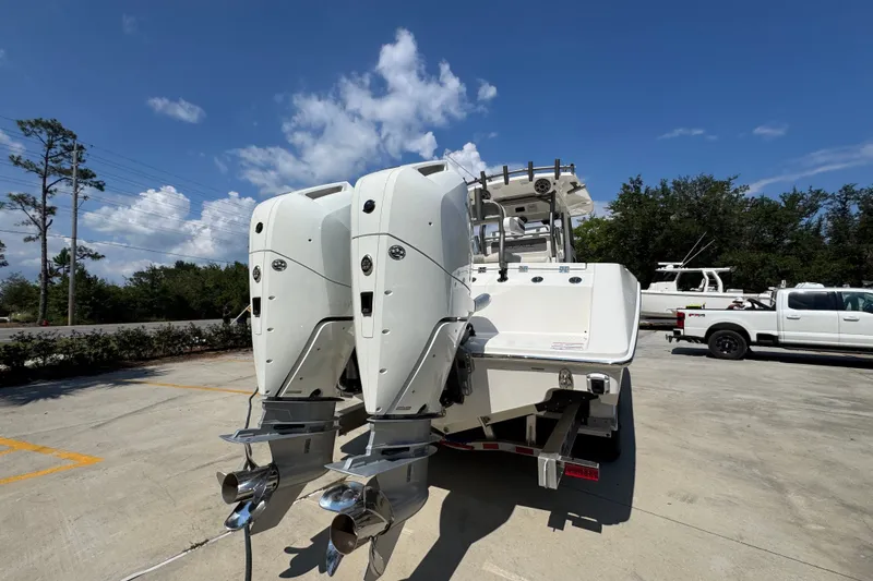 Slide: The Image of 2027 Solace 32CS boat with dual outboard engines in a sunny parking lot. - 14
