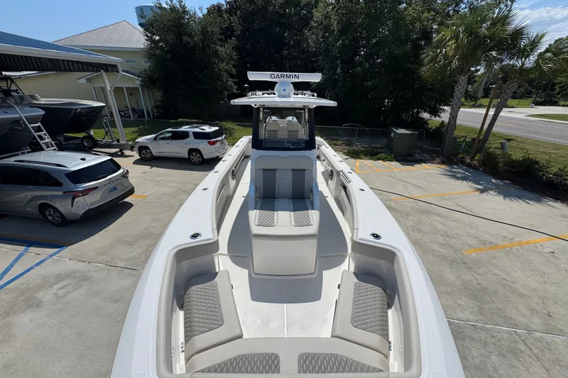 Slide: The Image of 2027 Solace 32CS boat with Garmin equipment, parked outdoors near vehicles and trees. - 23
