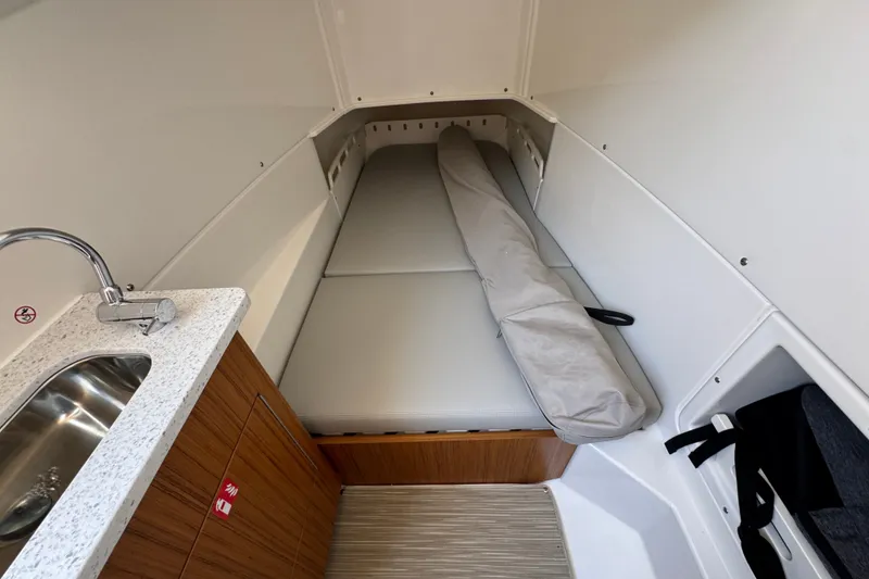 Slide: The Image of 2027 Solace 32CS cabin interior with compact bed and kitchenette. - 30