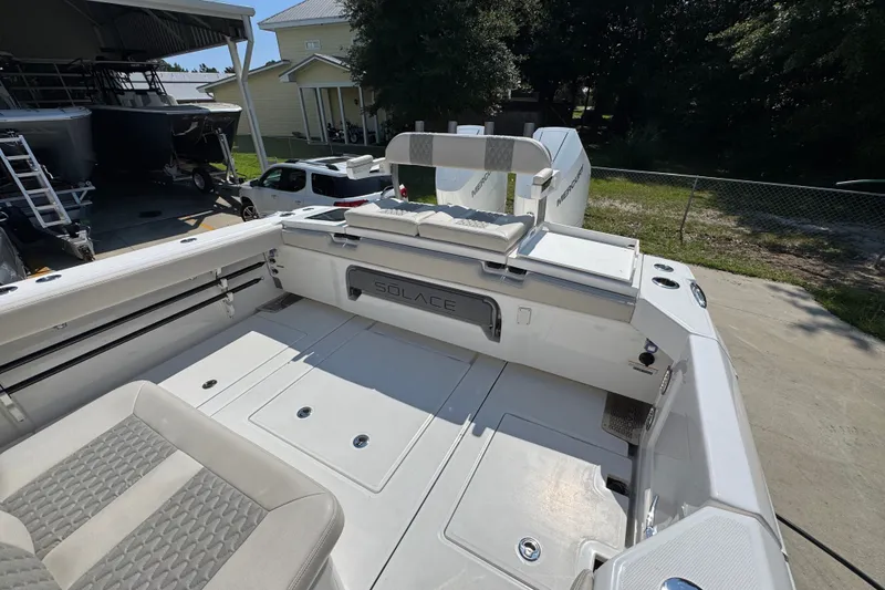 Slide: The Image of 2027 Solace 32CS boat interior with seating and storage, parked outdoors. - 50