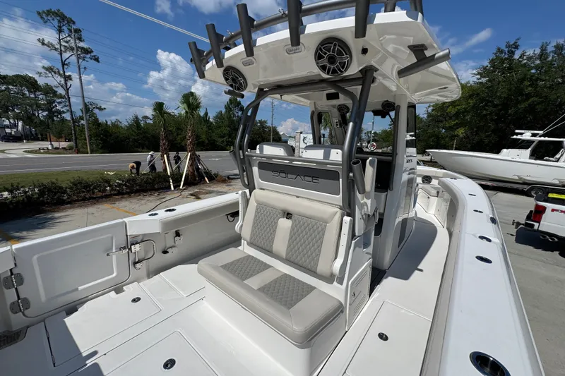 Slide: The Image of 2027 Solace 32CS boat with spacious seating and modern design, parked outdoors. - 44