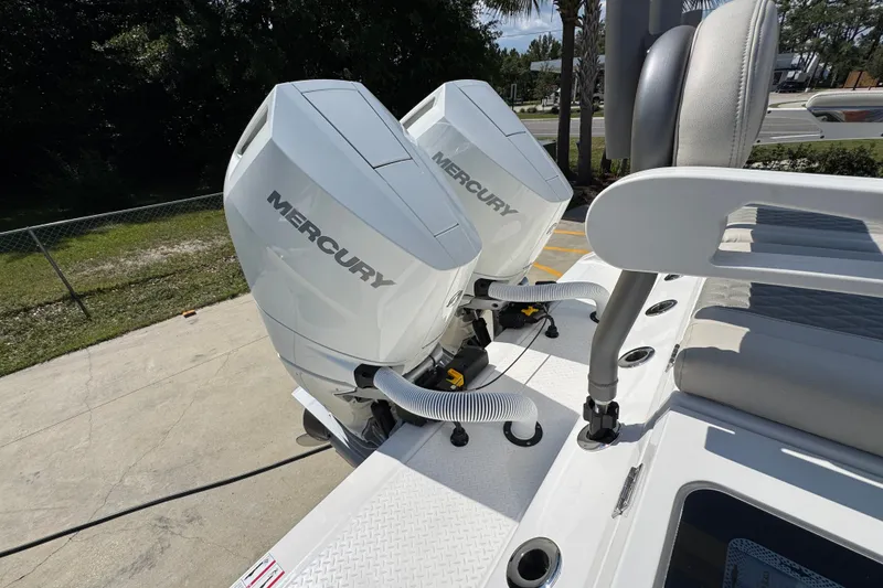 Slide: The Image of Twin Mercury outboard engines on a 2027 Solace 32CS boat, parked outdoors. - 54