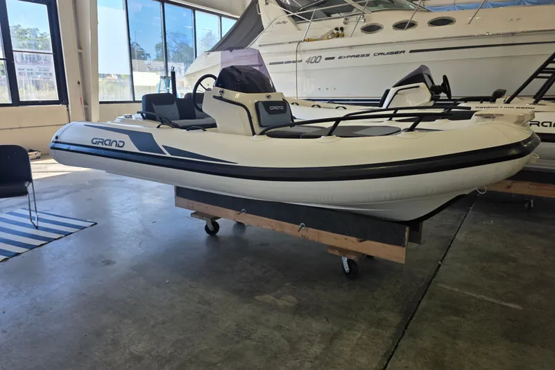 Slide: The Image of 2027 Grand Inflatables G420 boat displayed indoors, featuring sleek design and modern aesthetics. - 2