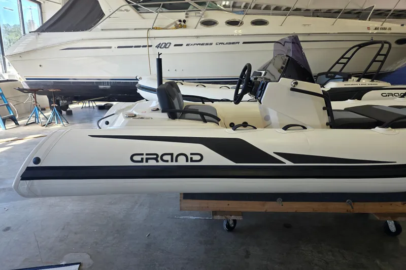 Slide: The Image of 2027 Grand Inflatables G420 boat in showroom, side view with sleek design. - 6