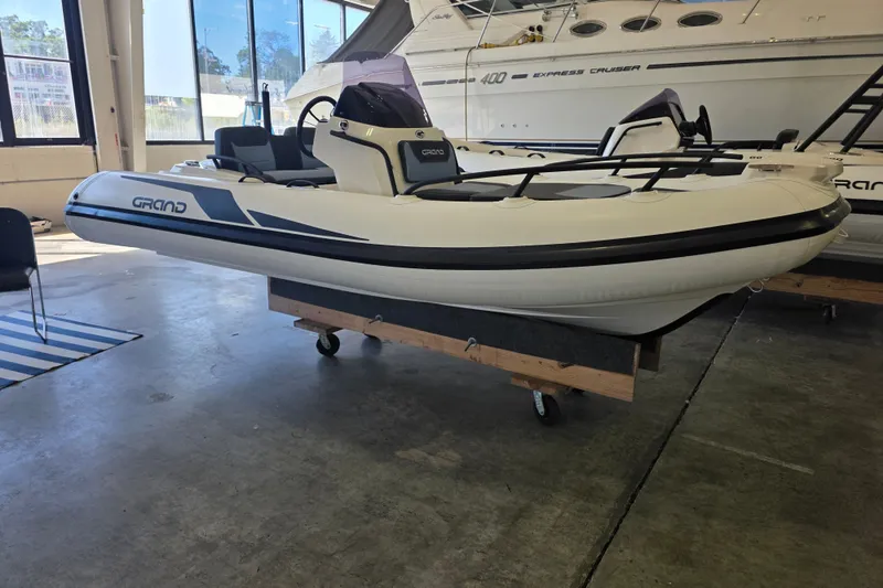 The Image of 2027 Grand Inflatables G420 boat displayed indoors on a wheeled stand. - 0