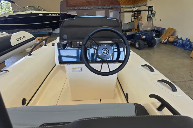 Slide: The Image of Interior view of 2027 Grand Inflatables G420 boat, featuring steering wheel and control panel. - 10
