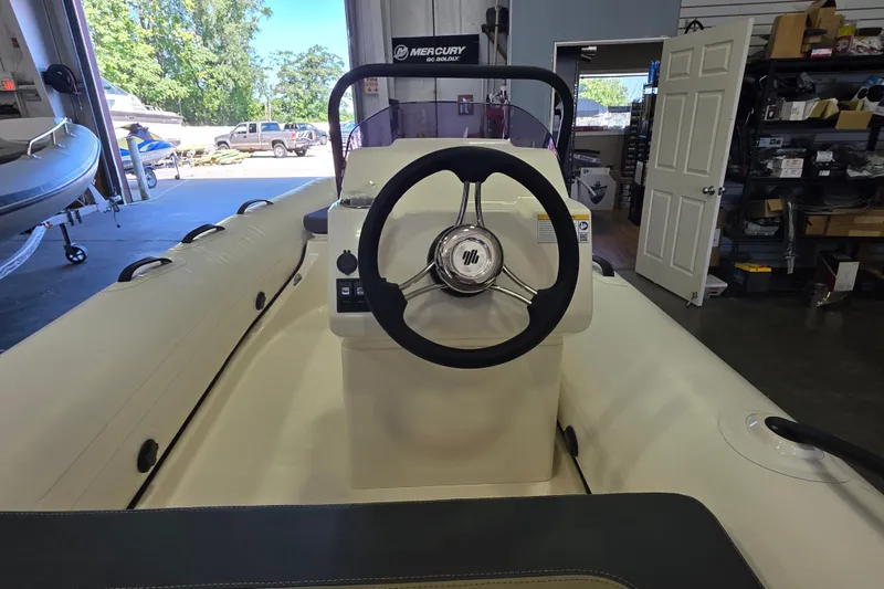 Slide: The Image of 2027 Grand Inflatables G380N boat interior with steering wheel in a showroom. - 9