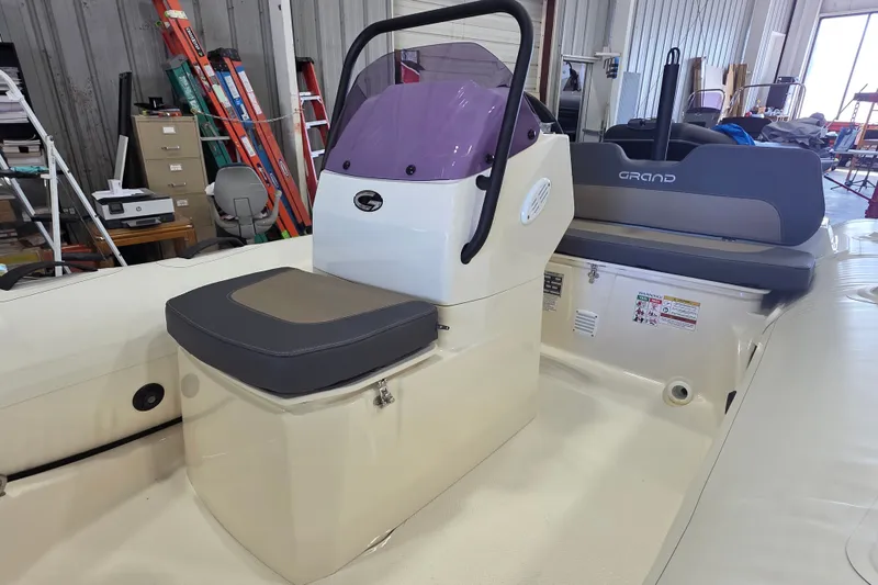 Slide: The Image of 2027 Grand Inflatables G380N boat interior with seating and control console in a workshop. - 12