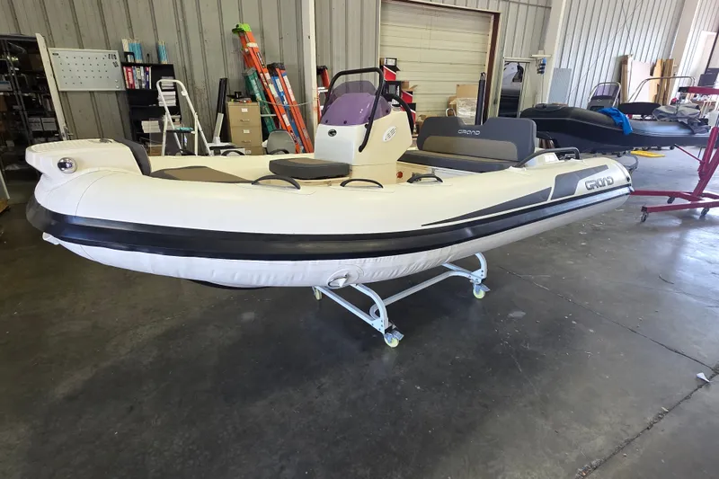 Slide: The Image of 2027 Grand Inflatables G380N boat in a warehouse setting, showcasing sleek design and modern features. - 5