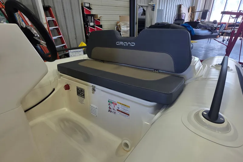 Slide: The Image of 2027 Grand Inflatables G380N boat interior with cushioned seating in a workshop setting. - 8