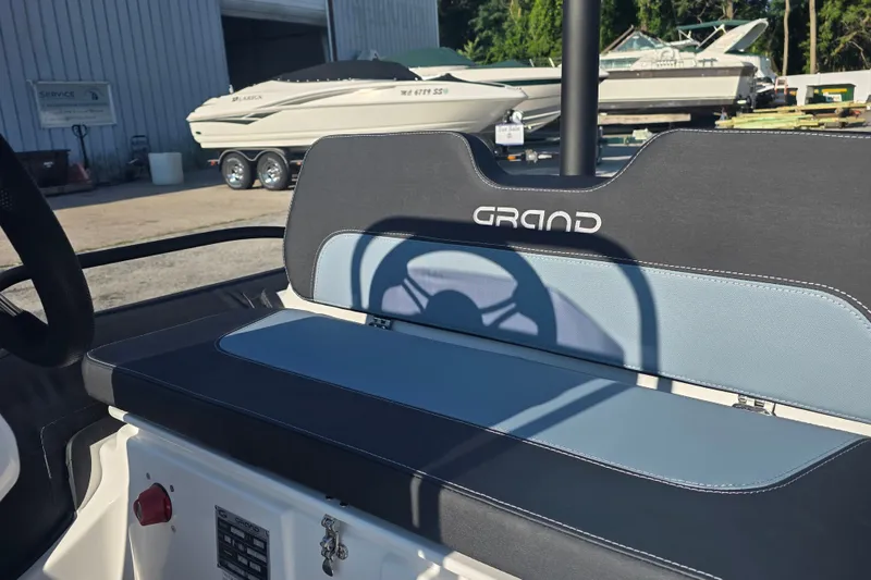 Slide: The Image of 2027 Grand Inflatables G380N boat interior with sleek seating and steering wheel. - 11
