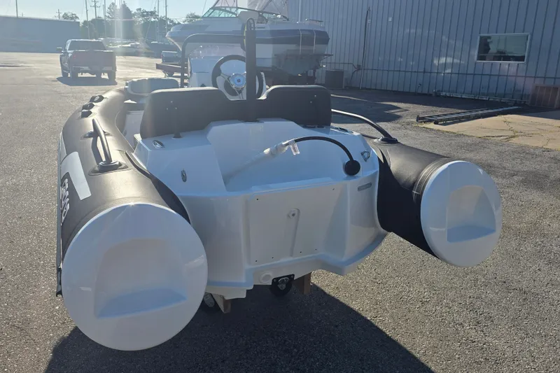 Slide: The Image of 2027 Grand Inflatables G380N boat, rear view, parked outdoors on a sunny day. - 7