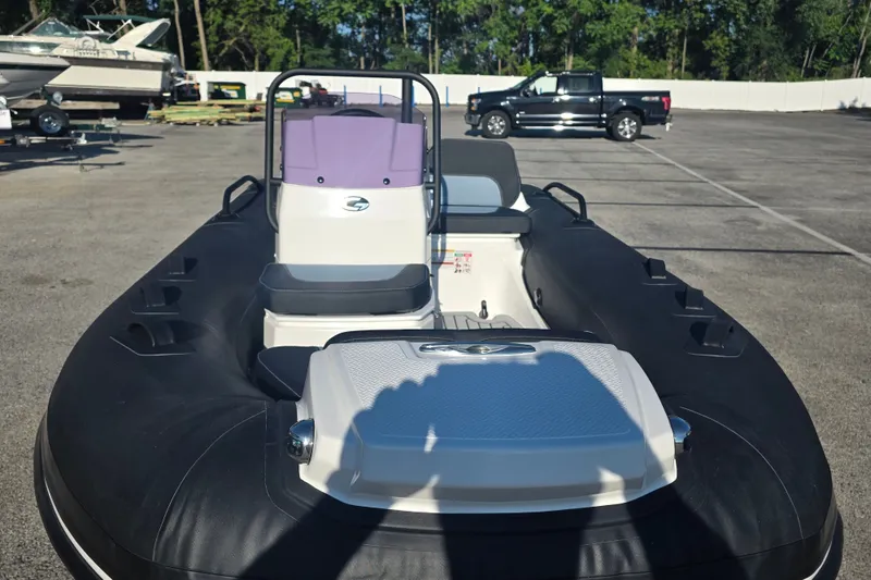 Slide: The Image of 2027 Grand Inflatables G380N boat in a parking lot, showcasing sleek design and seating. - 3