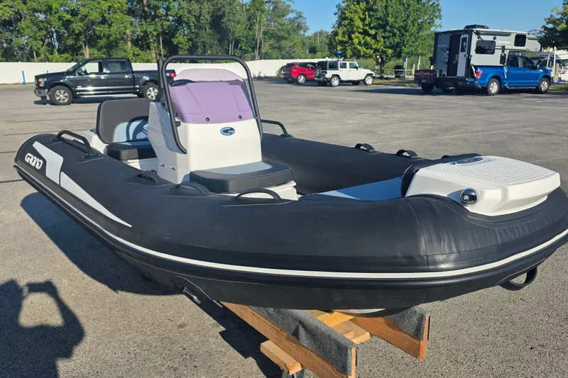 Slide: The Image of 2027 Grand Inflatables G380N boat in a parking lot, showcasing sleek design and modern features. - 2