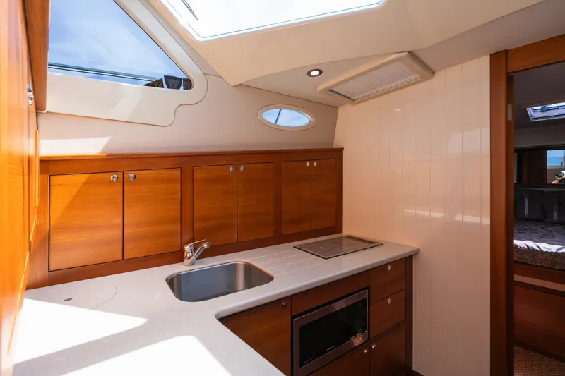 Slide: The Image of 2017 Palm Beach Motor Yachts PB42 interior kitchen with wood cabinetry and modern appliances. - 42
