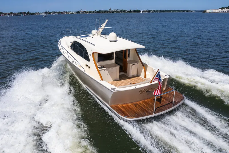 Slide: The Image of 2017 Palm Beach Motor Yachts PB42 cruising on open water, rear view with American flag. - 6