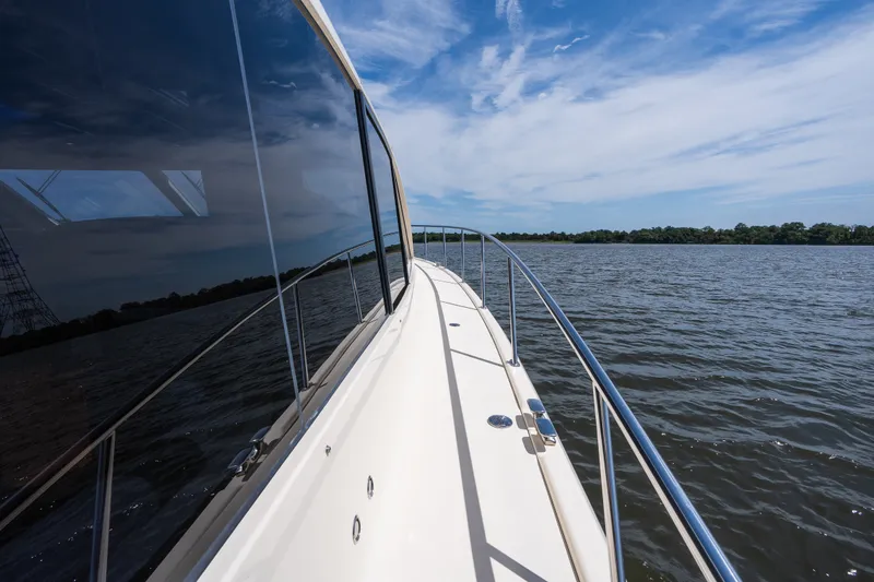 Slide: The Image of 2017 Palm Beach Motor Yachts PB42 cruising on a serene lake under a blue sky. - 22