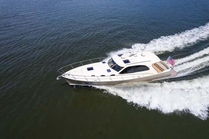 Slide: The Image of 2017 Palm Beach Motor Yachts PB42 cruising on open water, displaying sleek design and American flag. - 5