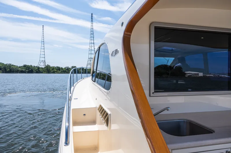 Slide: The Image of 2017 Palm Beach Motor Yachts PB42 cruising on a serene waterway with clear skies. - 19