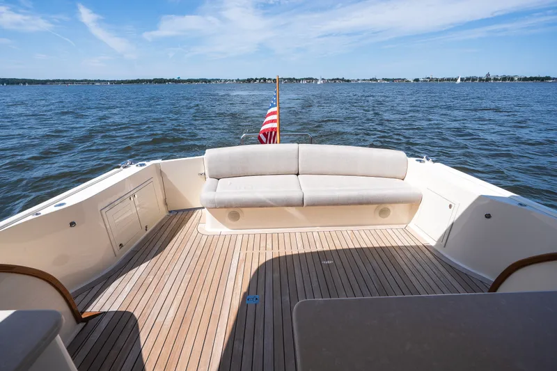 Slide: The Image of 2017 Palm Beach Motor Yachts PB42 deck with seating, overlooking serene waters. - 16