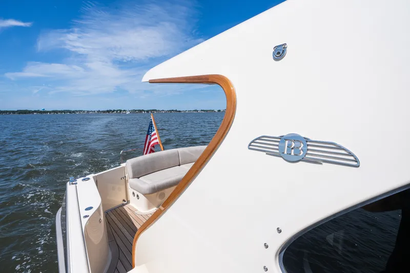 Slide: The Image of 2017 Palm Beach Motor Yachts PB42 cruising on open water, featuring elegant design and American flag. - 21