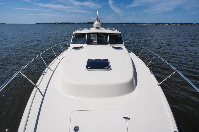 Slide: The Image of 2017 Palm Beach Motor Yachts PB42 cruising on open water under a clear blue sky. - 25