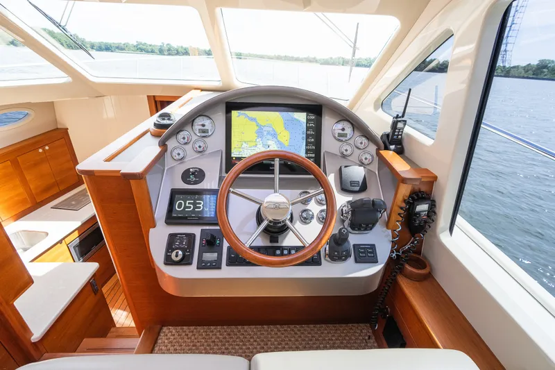 Slide: The Image of Helm of 2017 Palm Beach Motor Yachts PB42 with navigation instruments and wooden accents. - 37
