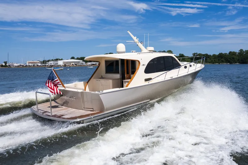 Slide: The Image of 2017 Palm Beach Motor Yachts PB42 cruising on water, American flag displayed, clear sky. - 58